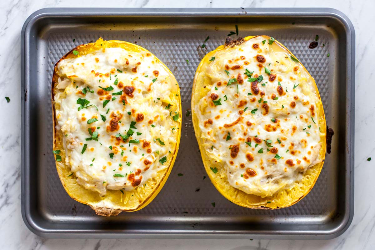 Two spaghetti squash boats on a silver sheet pan