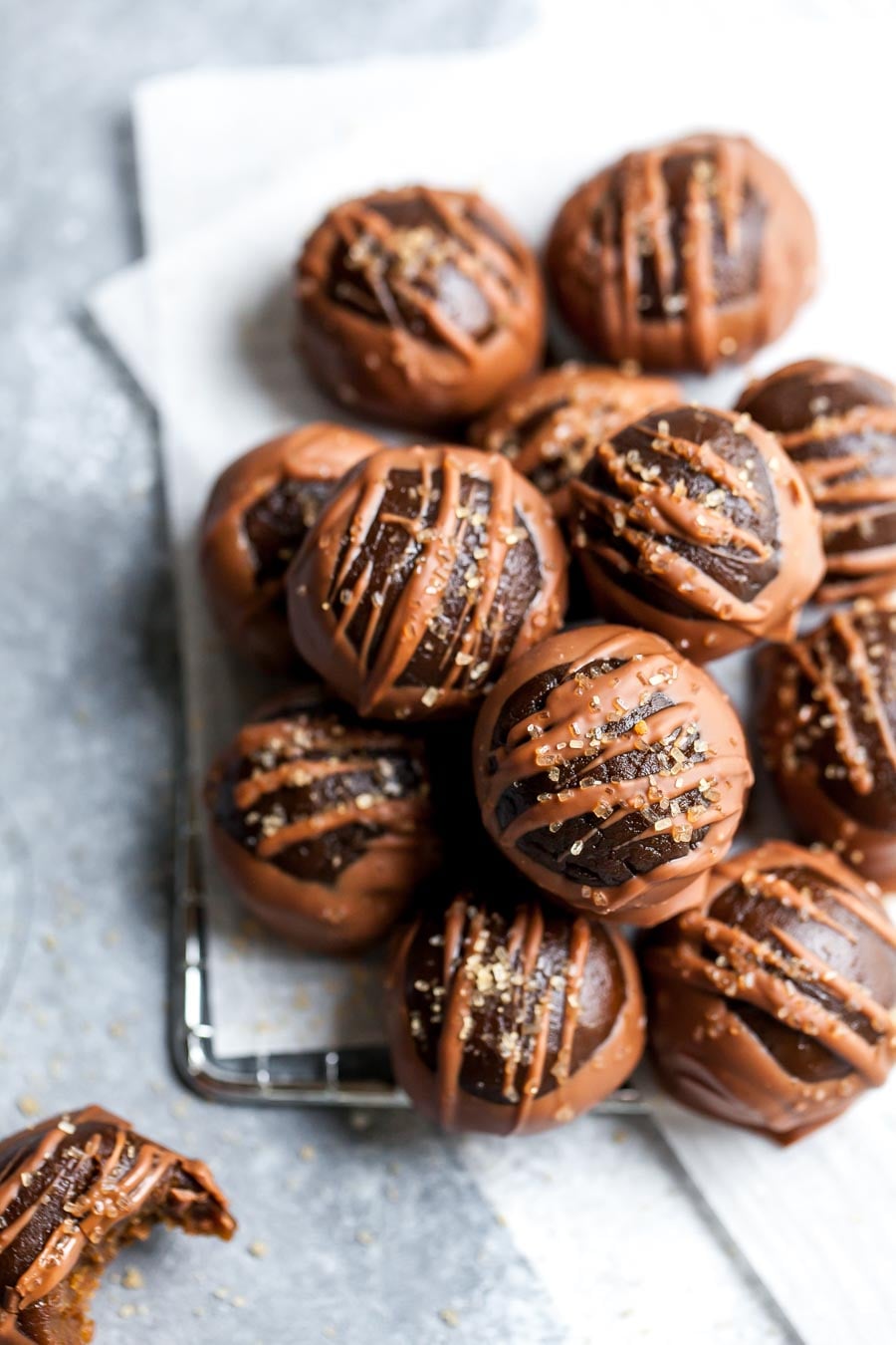 Vegan buckeyes stacked on top of each other arranged on a blue surface.