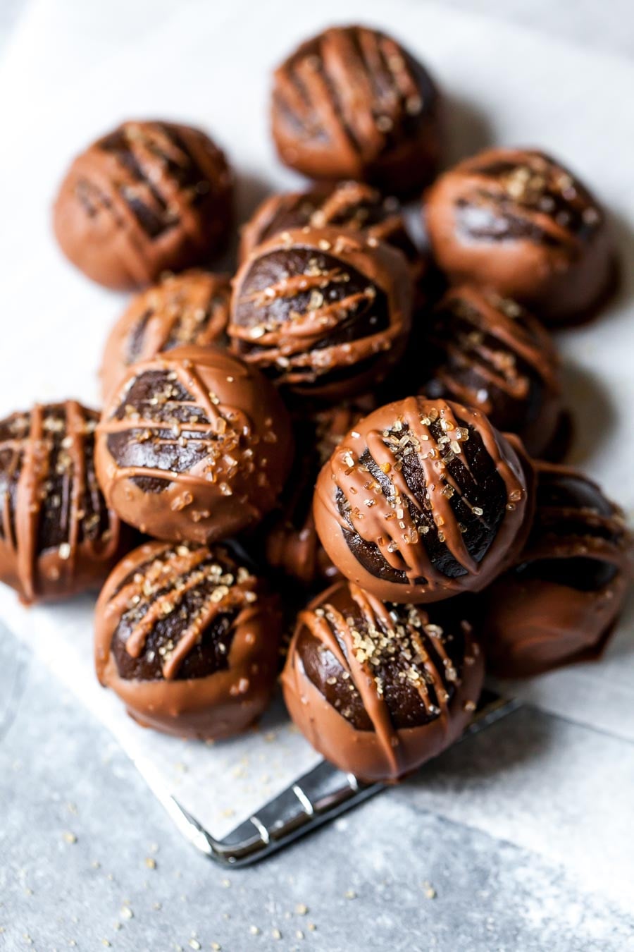 Vegan gingerbread buckeyes arranged on a blue surface topped with raw sugar granules.