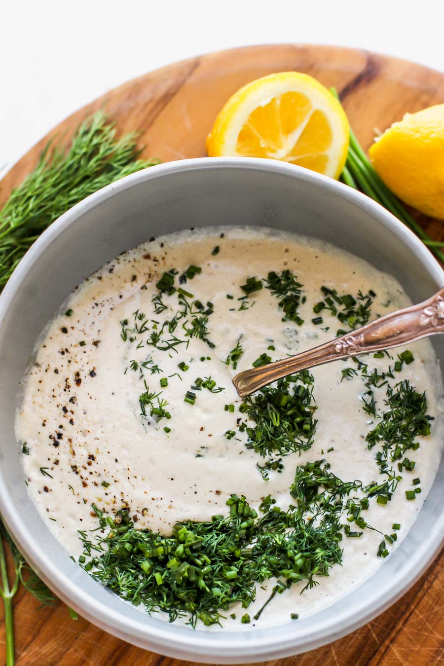 Sunflower seed ranch dressing in a gray bowl topped with herbs