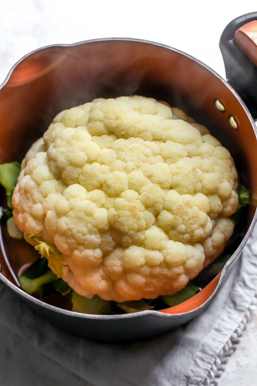 Pesto-Roasted Whole Cauliflower with Creamy Garlic Sauce