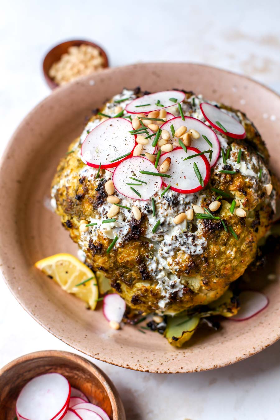Pesto-Roasted Whole Cauliflower with Creamy Garlic Sauce