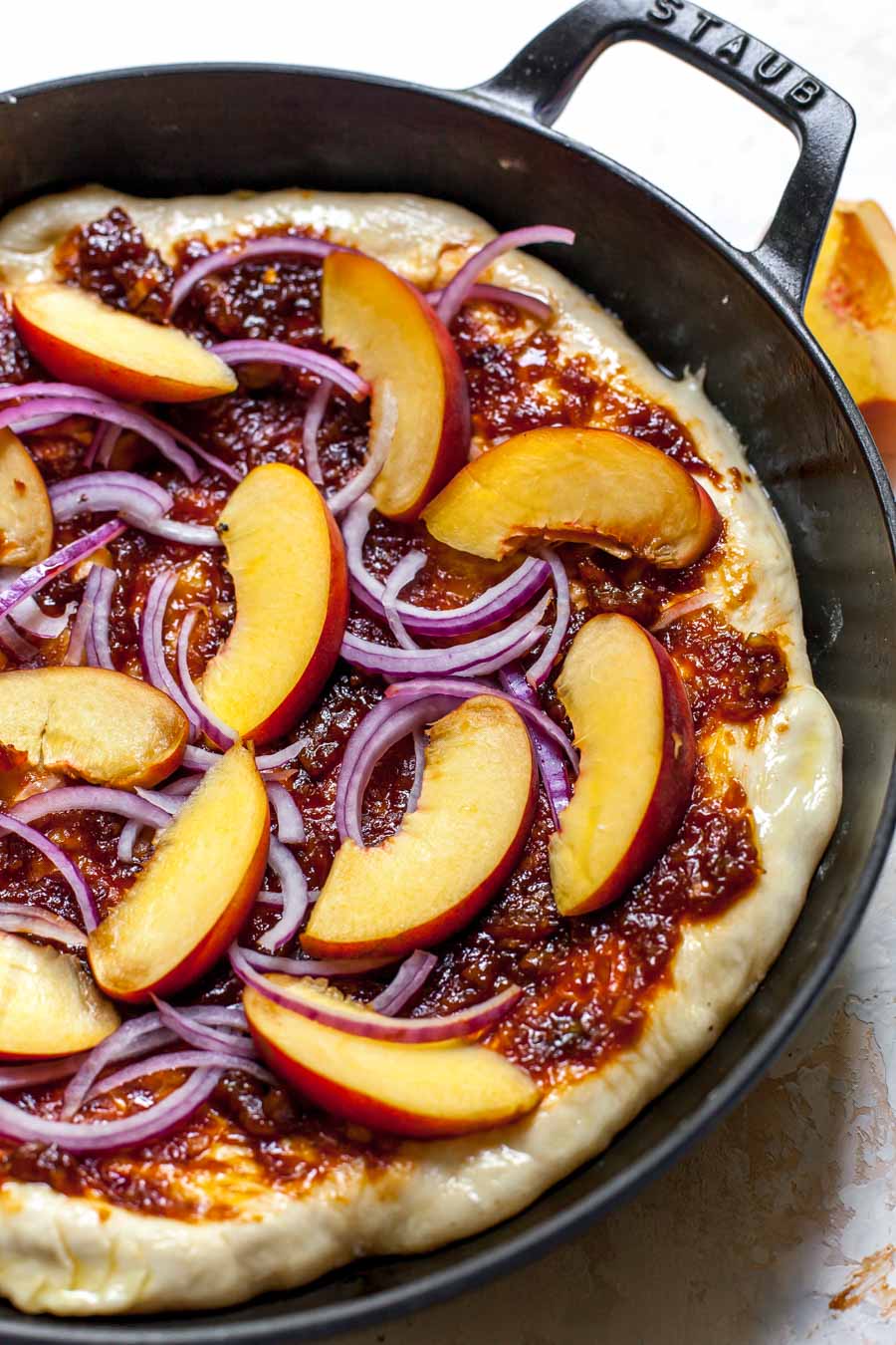 Stove top pizza with peach-BBQ sauce, peaches, and red onion