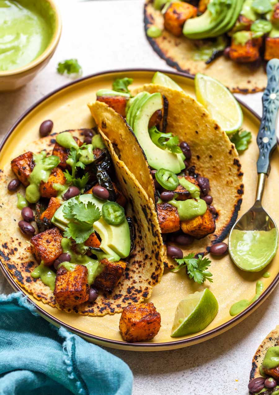 Chipotle butternut squash tacos styled on a yellow plate.