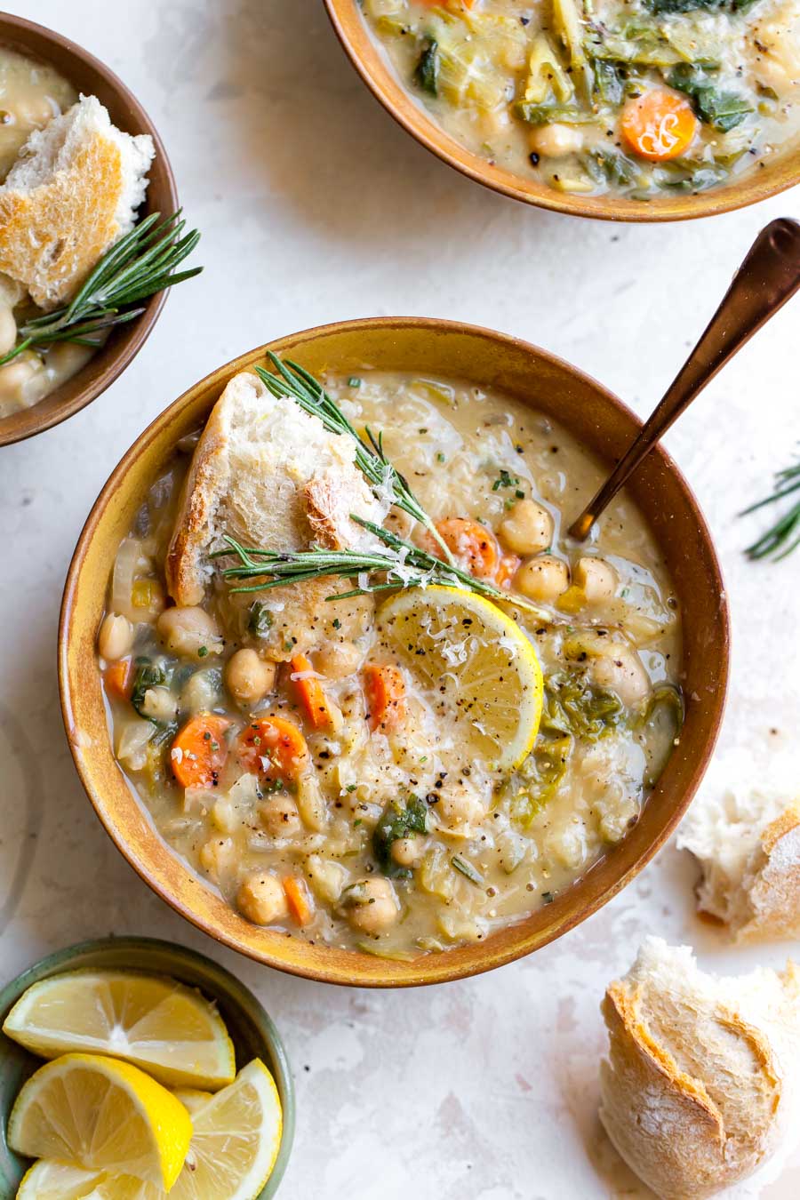 Single serving of white bean soup shown in a gold bowl with a gold spoon resting on the side