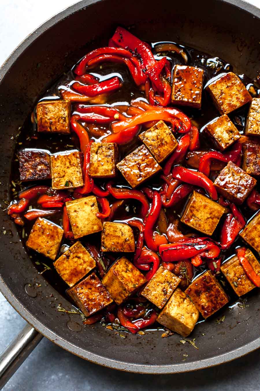 Balsamic Tofu in a skillet with roasted red peppers, garlic, and herbs