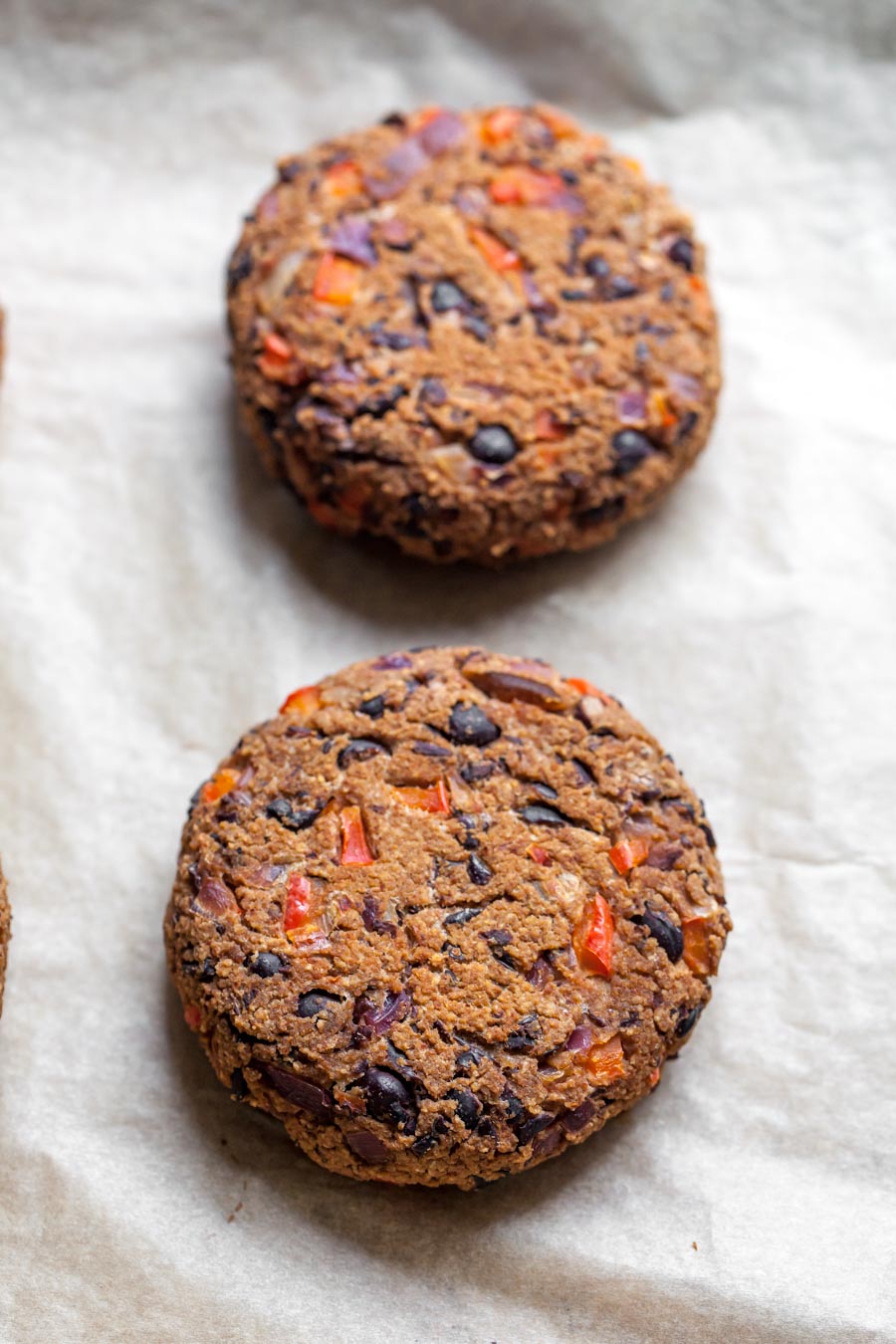 Black bean burgers being formed into patties and arranged on a baking sheet.