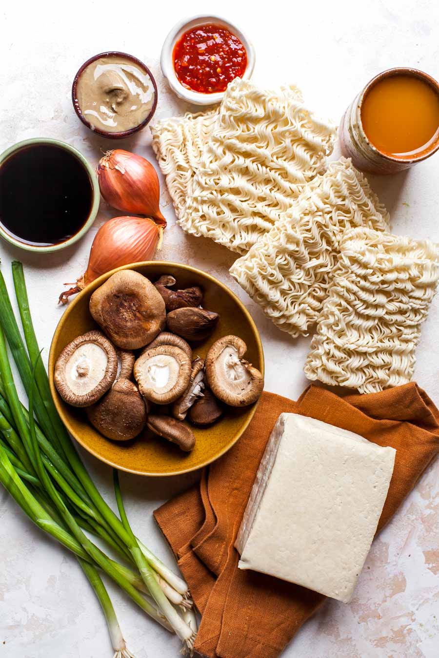 Ingredient layout showing ramen noodles, mushrooms, aromatics, and condiments