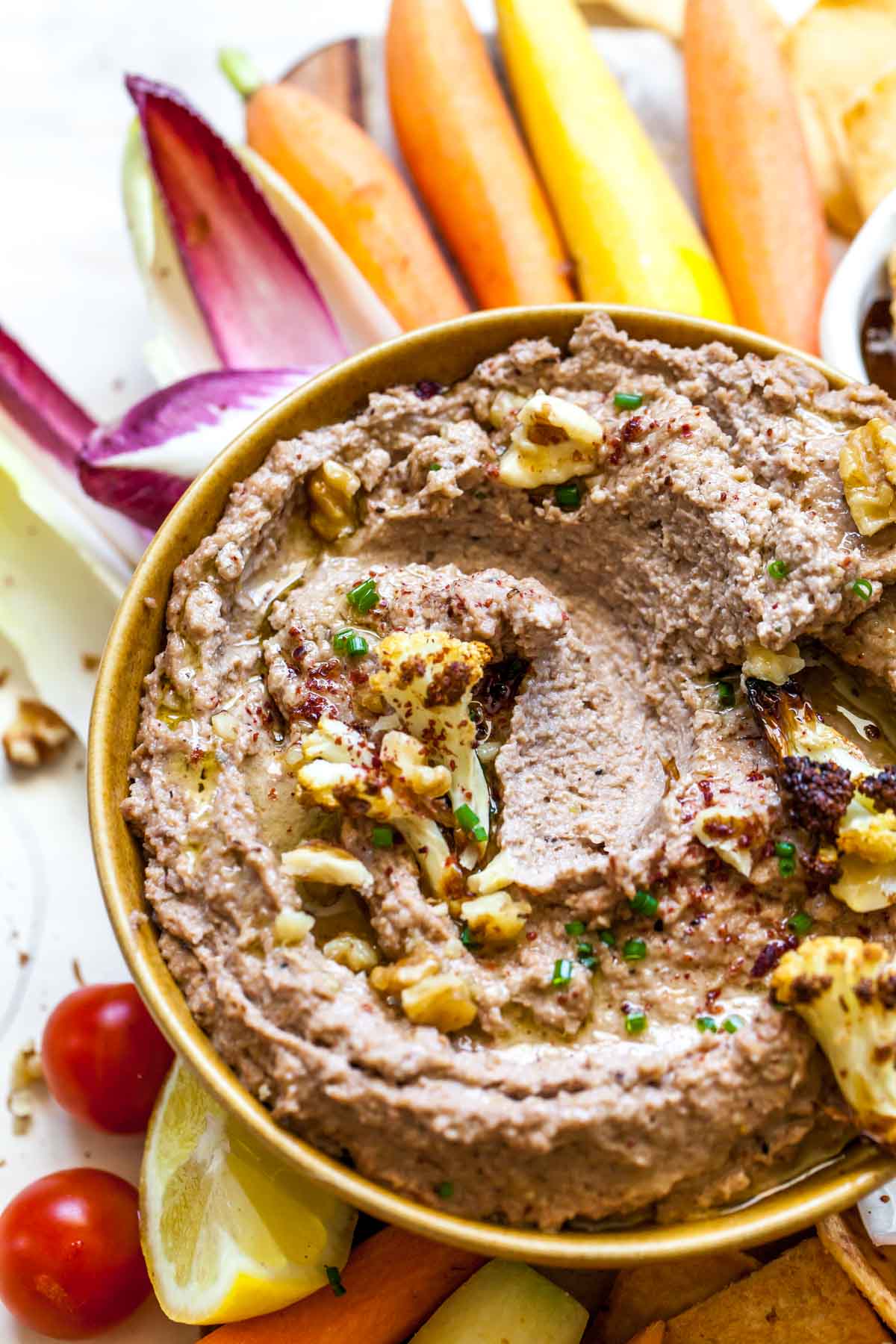 Cauliflower Walnut Dip in a bowl with a bite taken in the center