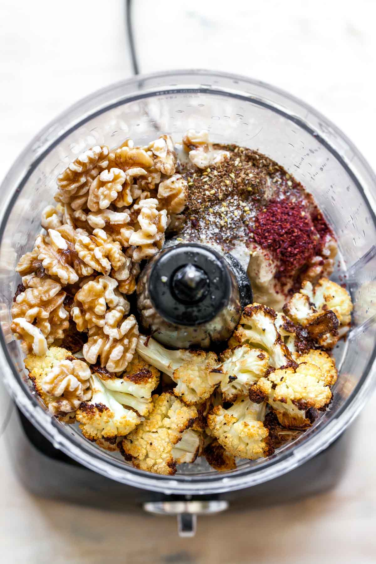 Walnuts, cauliflower, lemon, and spices in a food processor