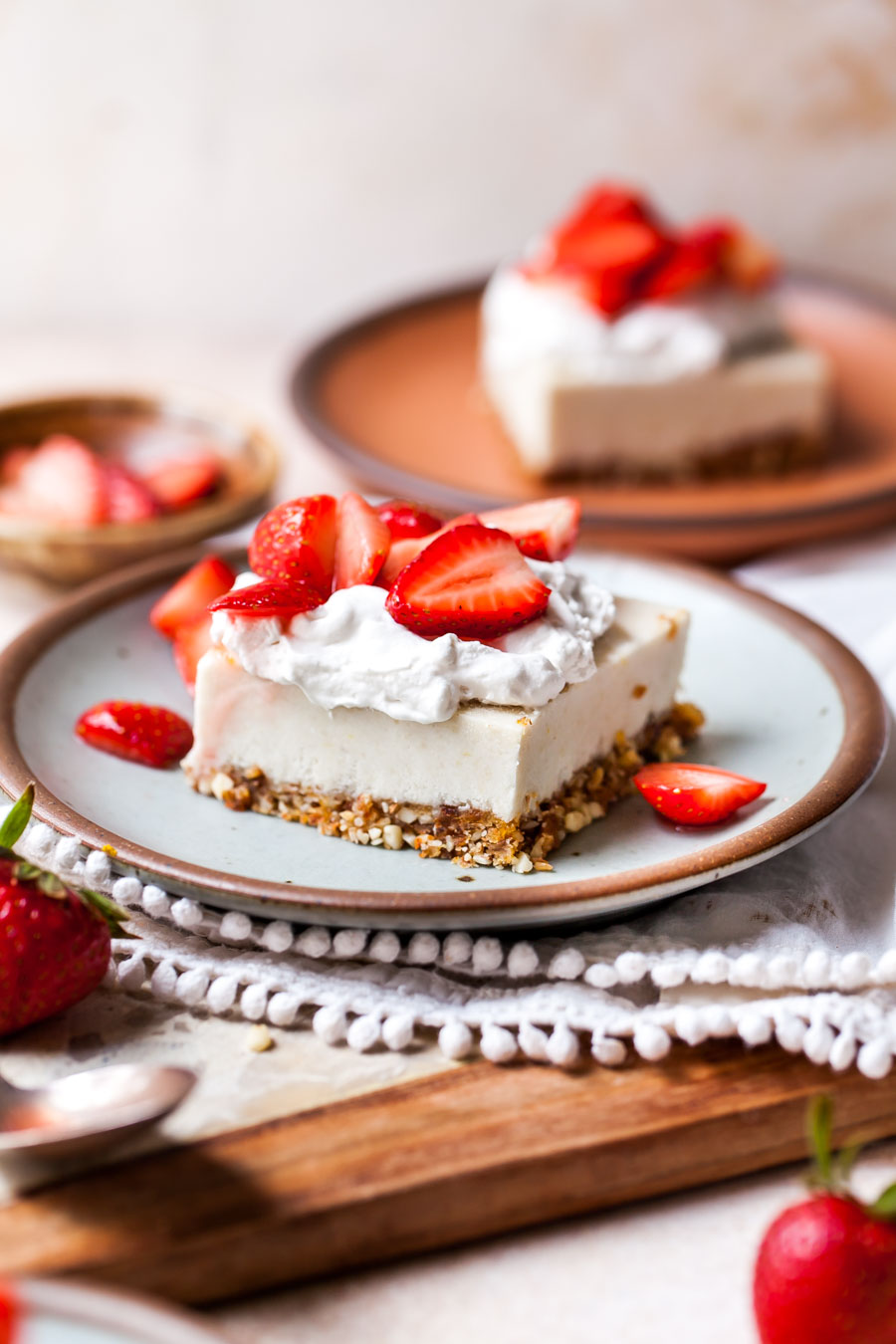 Vegan strawberry cheesecake bar styled on a small blue plate.