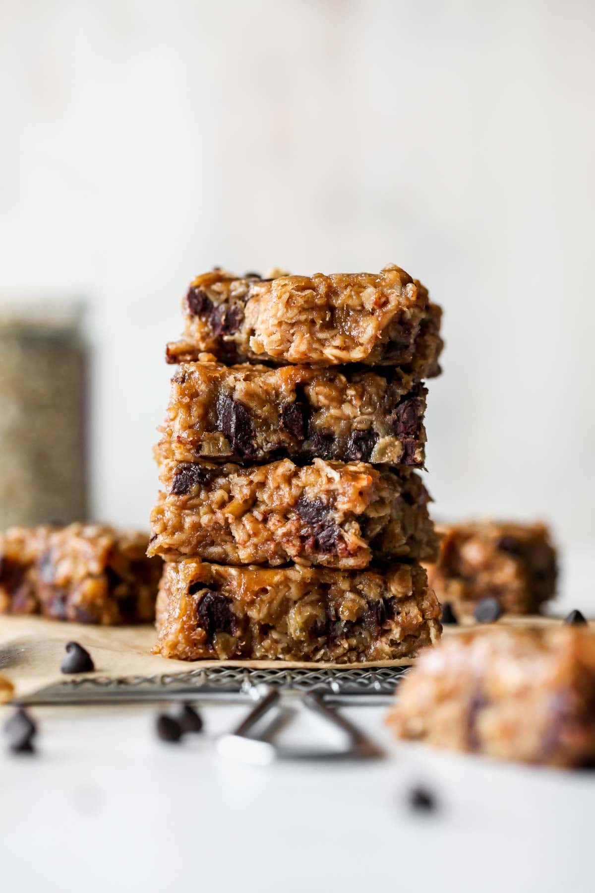 Banana peanut butter bars stacked on top of one another on a white work surface.
