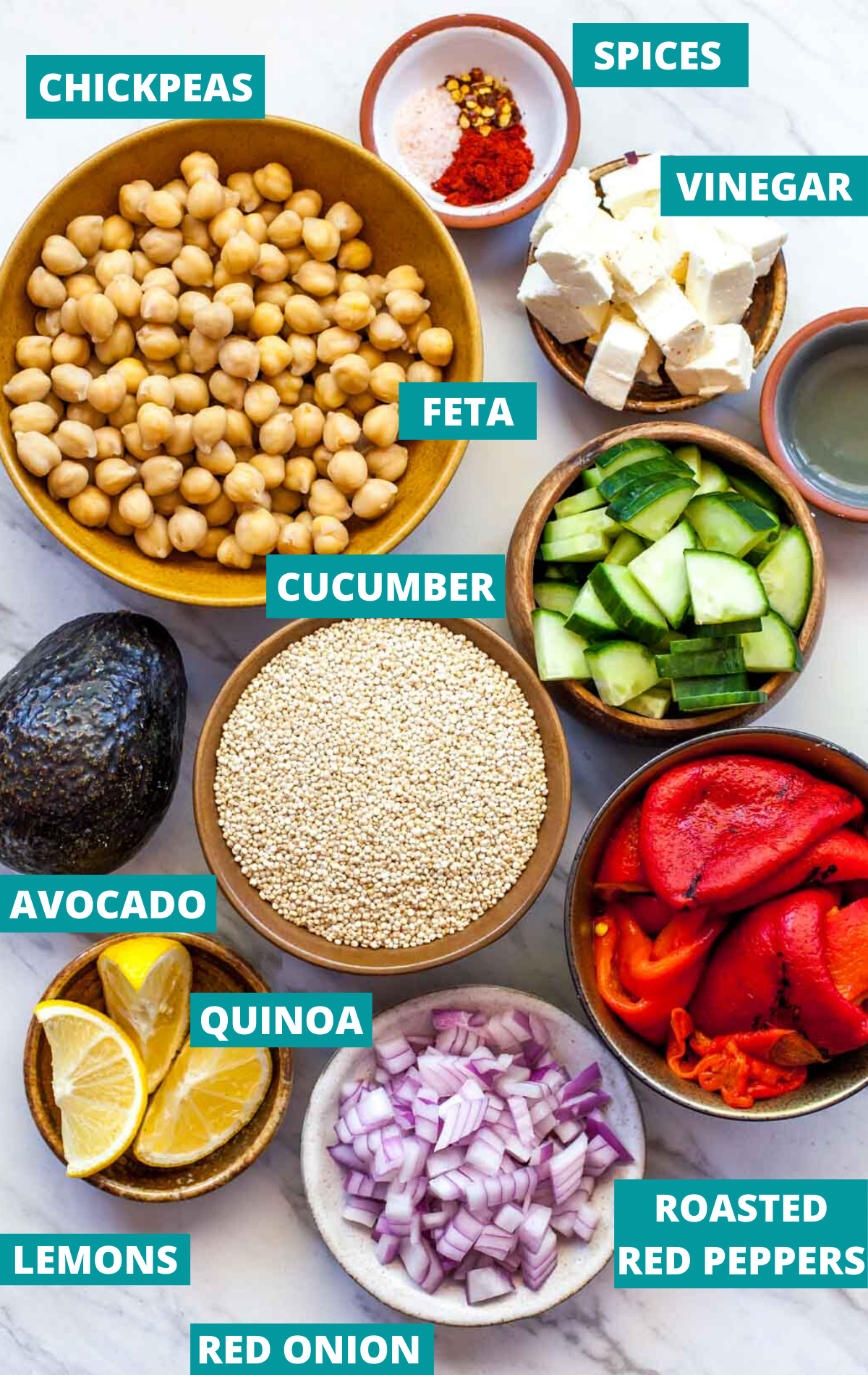 Quinoa, chickpeas, cucumber, red onion, red peppers, and spices in separate bowls with ingredient labels