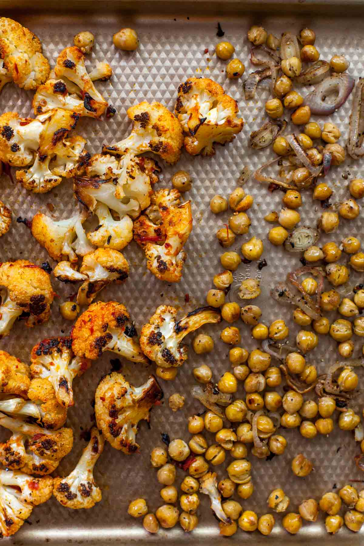 Roasted cauliflower and chickpeas on a baking sheet
