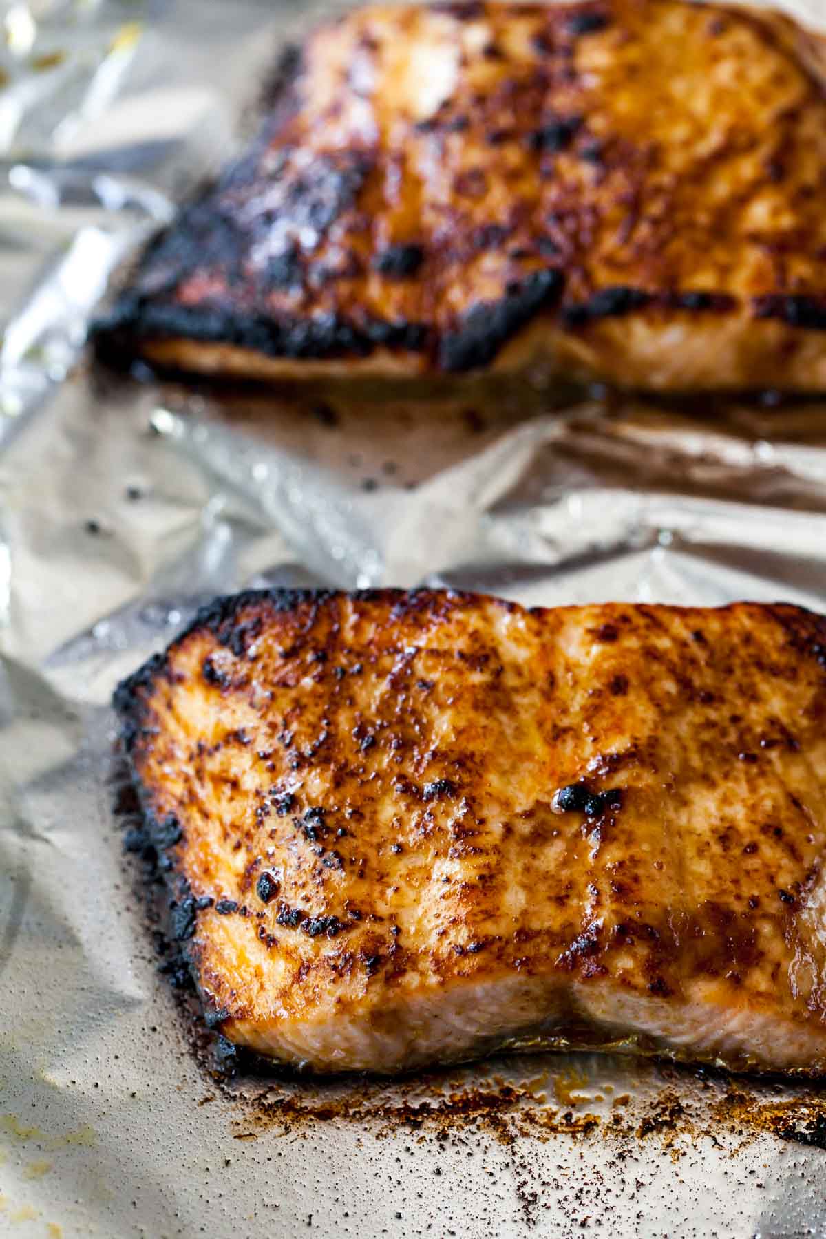 Broiled salmon fillets on a baking pan covered in foil