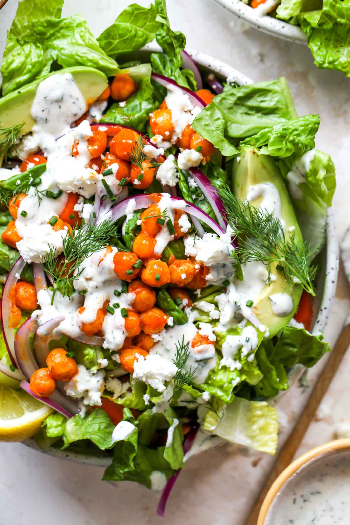 Close up of buffalo chickpea salad topped with yogurt ranch dressing