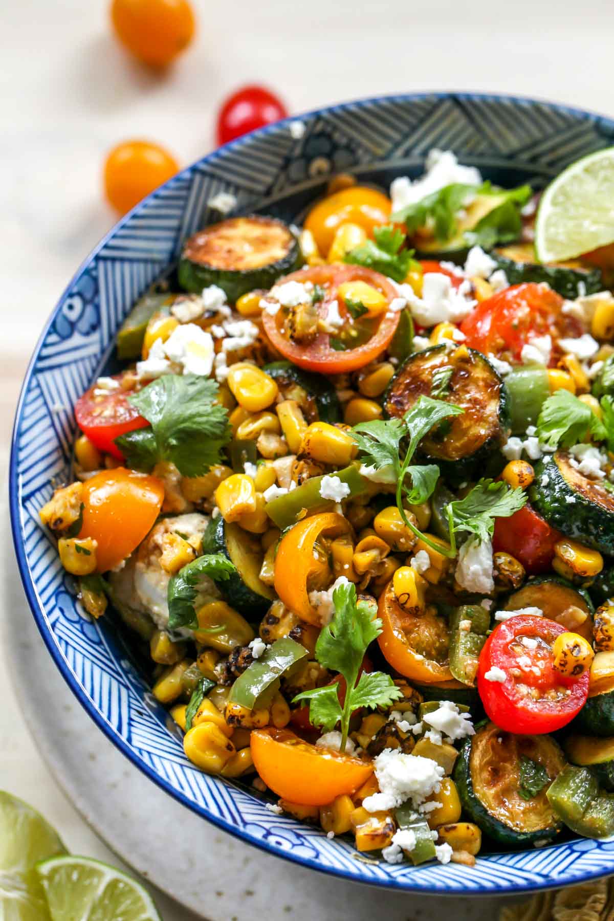 Zucchini and Corn Salad with tomatoes and cilantro in a blue bowl