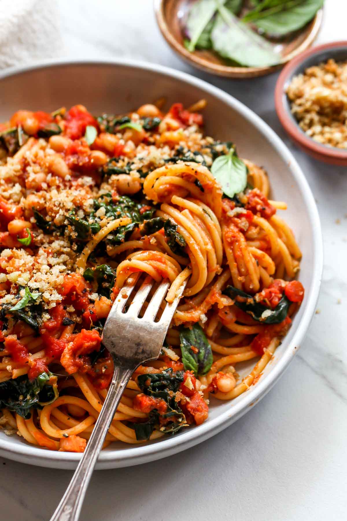 Fork twirling spaghetti on a gray plate