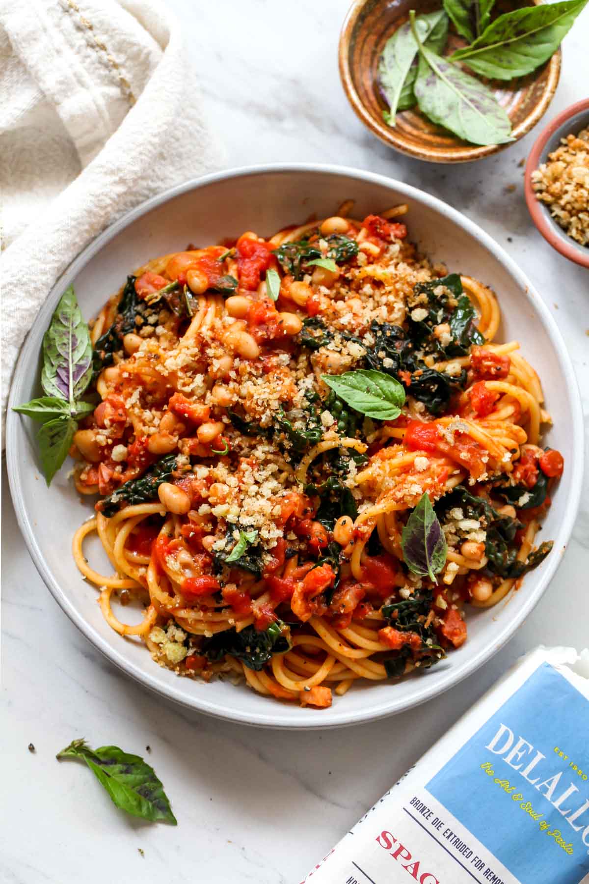 Plate of spaghetti pomodoro with package of DeLallo spaghetti peaking in the right corner