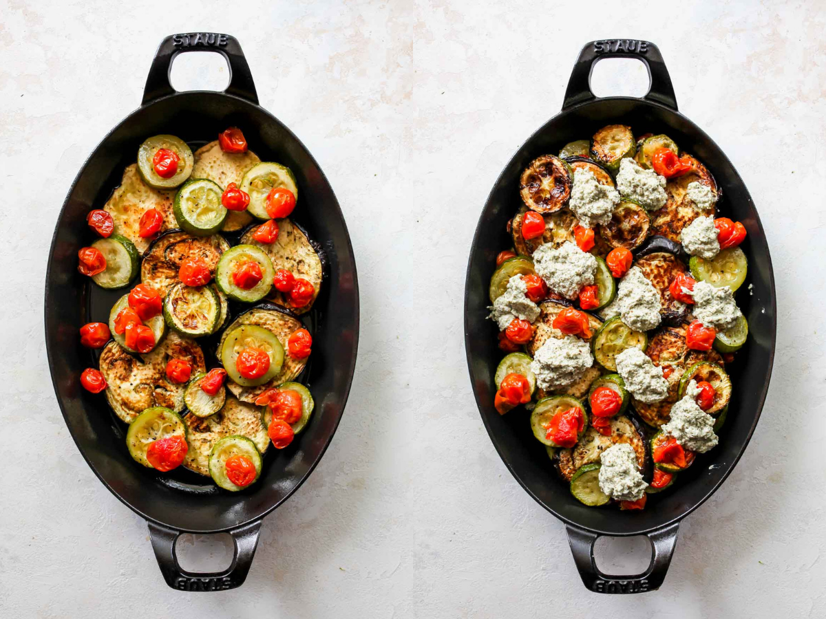 Slices of roasted eggplant, zucchini, and tomatoes being layered in a black pan