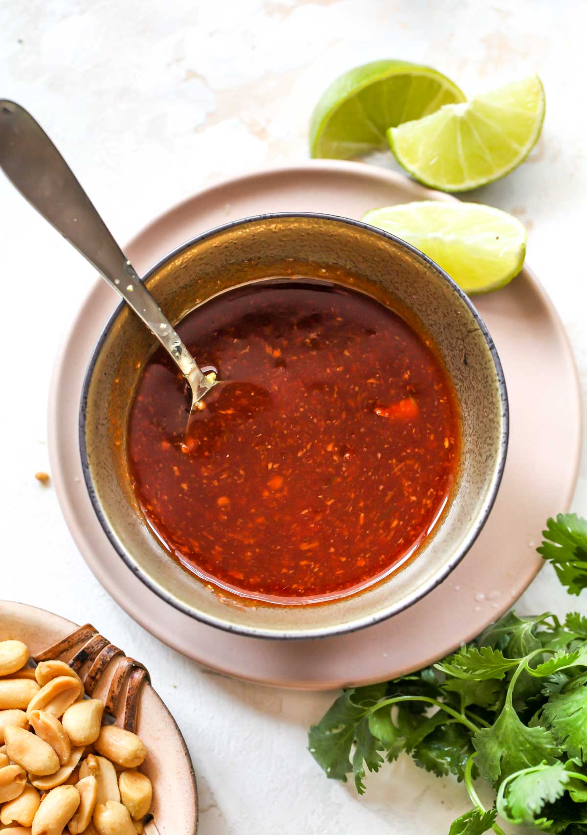 Asian BBQ sauce in a gold bowl on a pink plate
