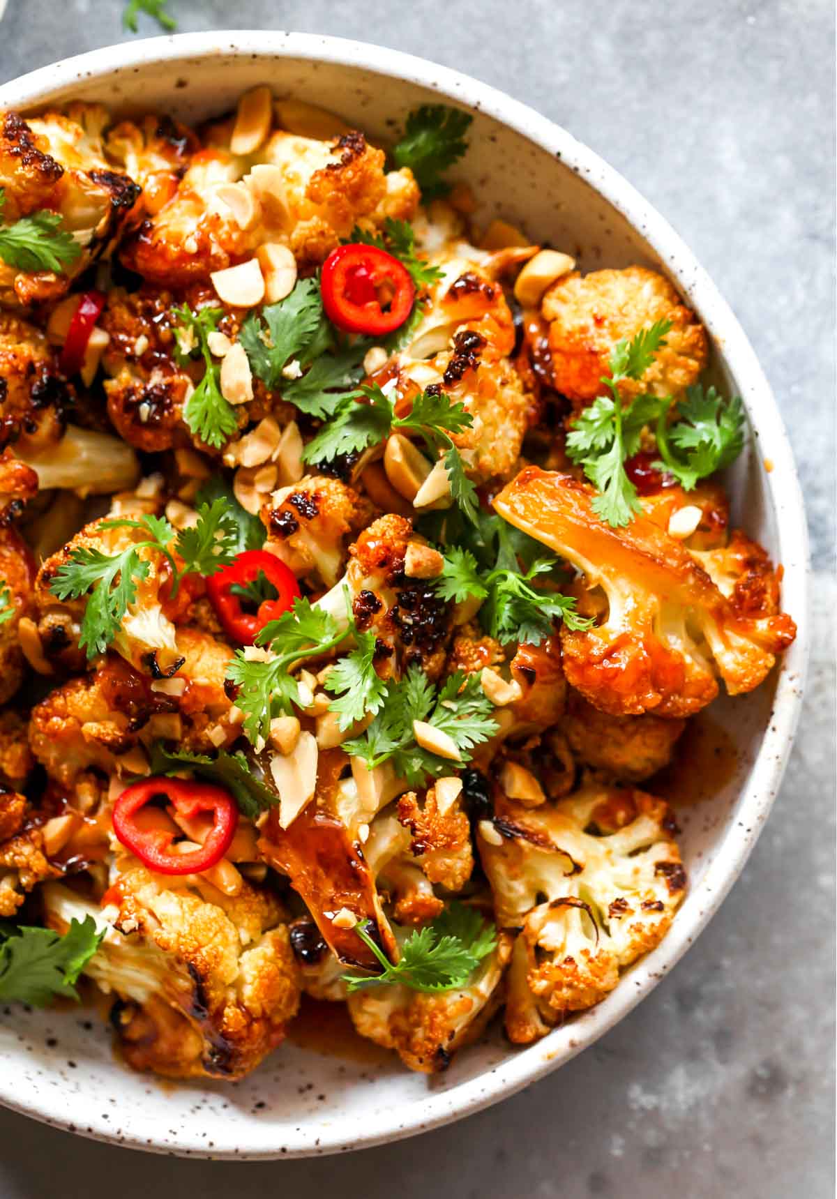 Close up of roasted cauliflower topped with peanuts and cilantro