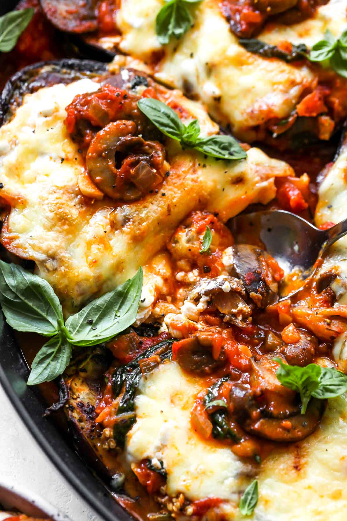 A spoon pulling out a bite of lasagna eggplant