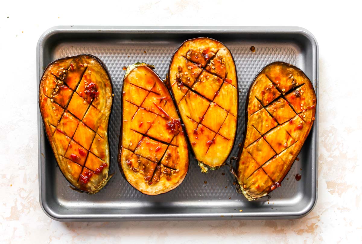 Roasted aubergine brushed with glaze on a sheet pan