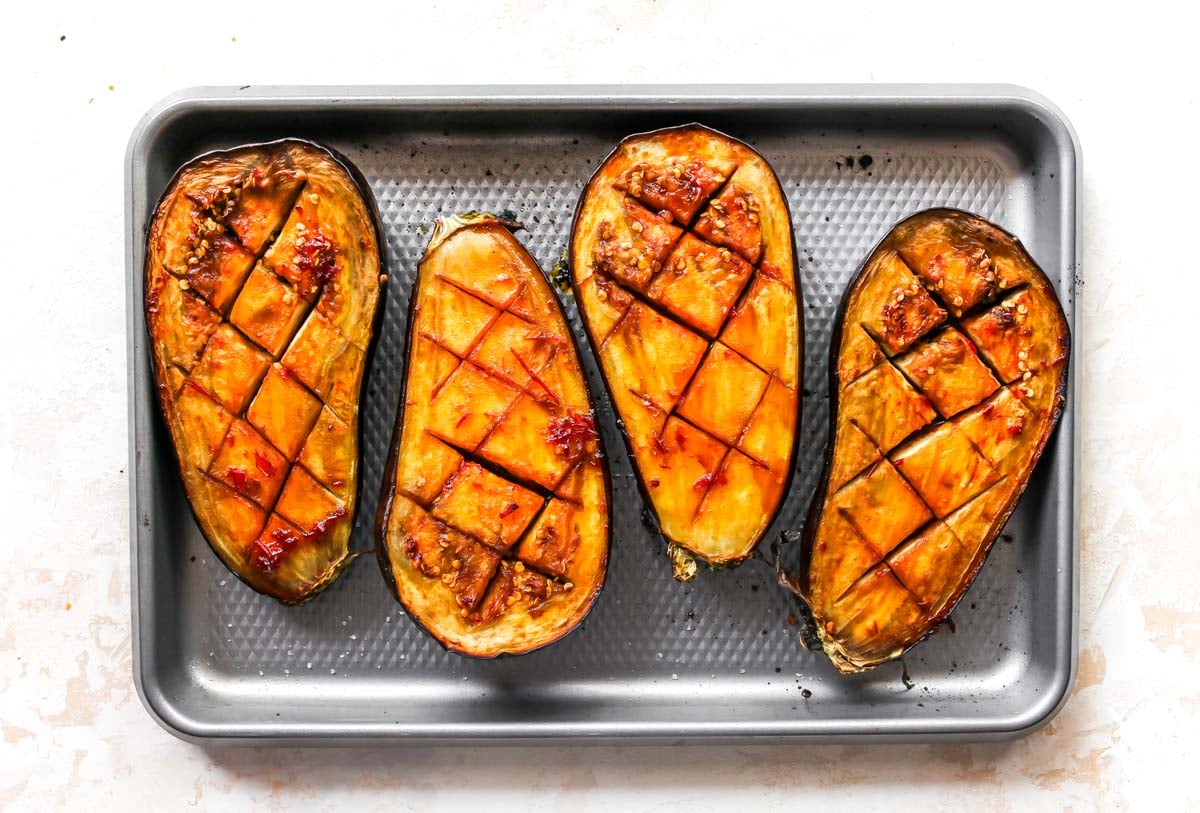 Roasted aubergine halves topped with glaze