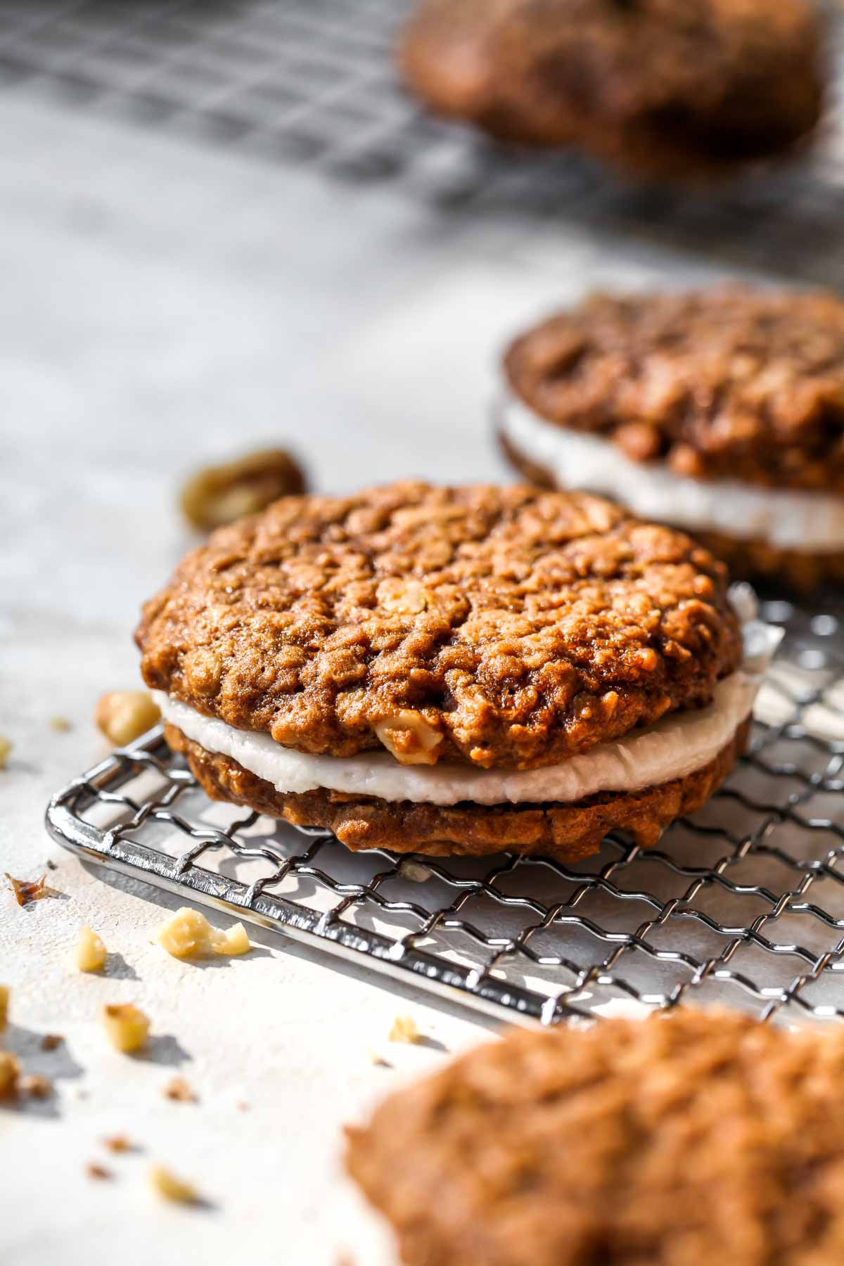 Side view of oatmeal creme pie with walnuts scattered around it