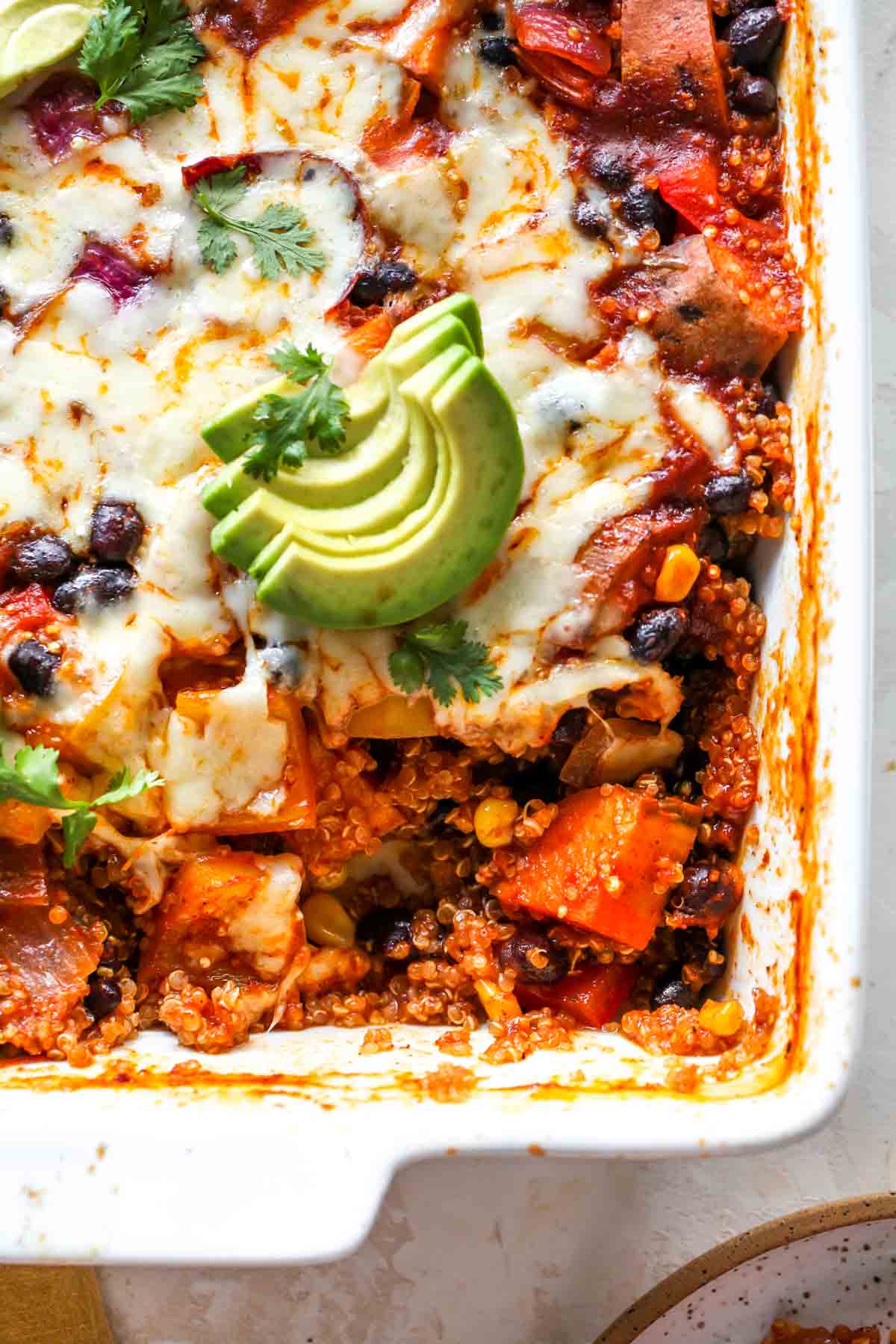 Close up of quinoa enchilada casserole with a scoop taken out