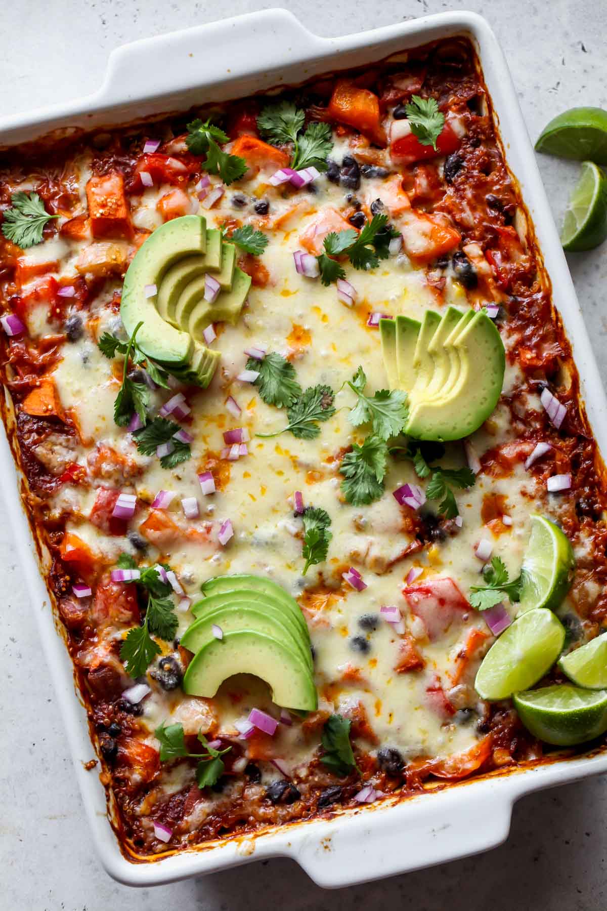 Enchilada quinoa casserole topped with avocado and cilantro