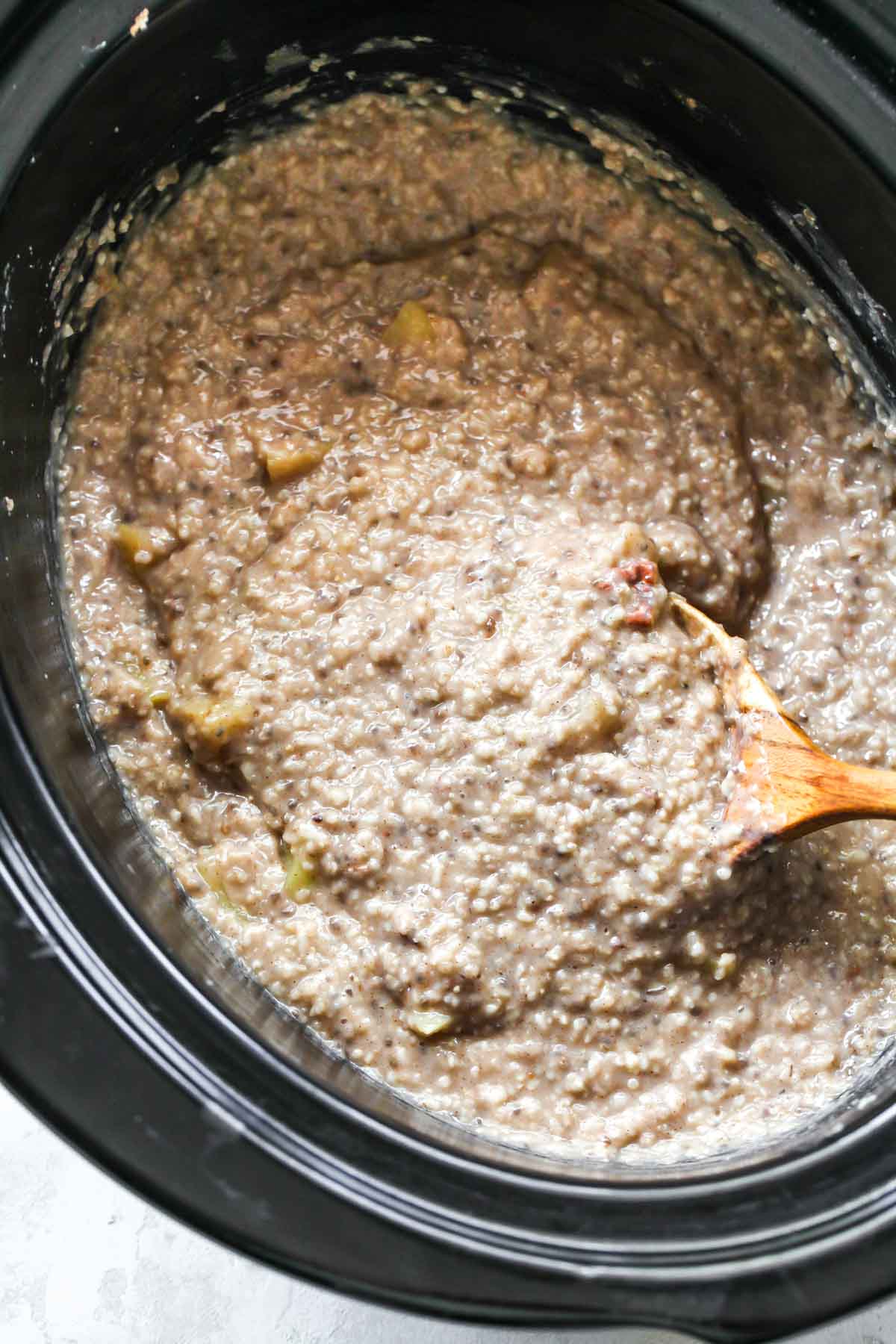 Steel cut oatmeal being stirred in a crockpot