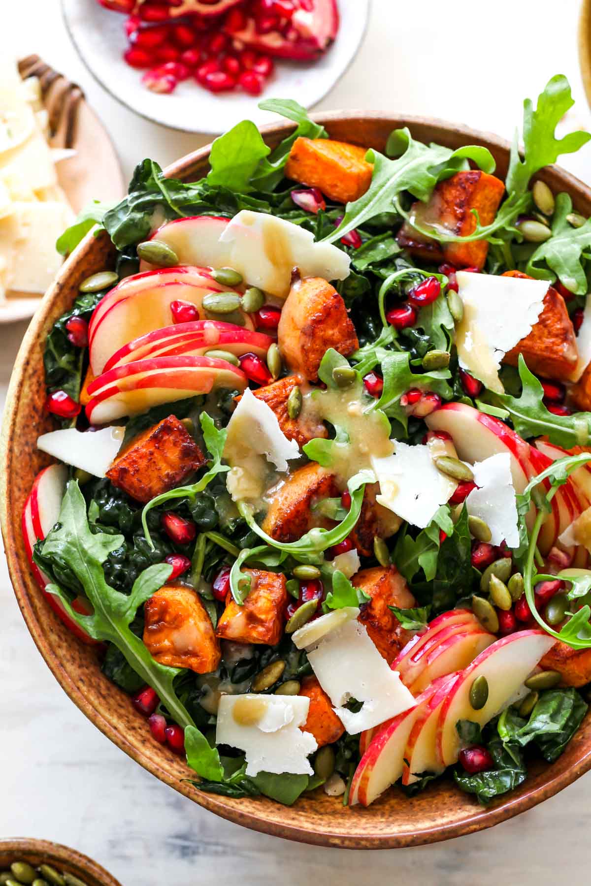 Thanksgiving salad recipe featuring lettuce, sweet potatoes, and apples in a wooden serving bowl.