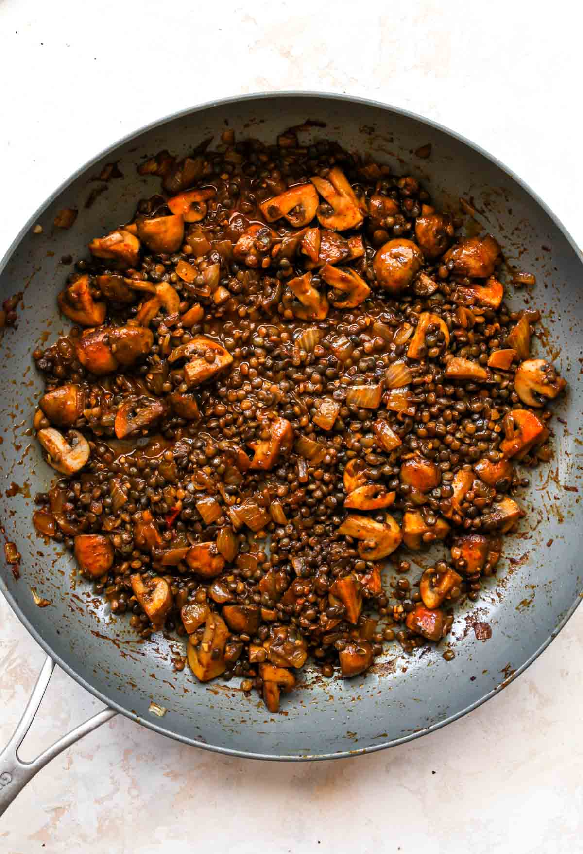 Mushrooms and lentils simmering in a skillet