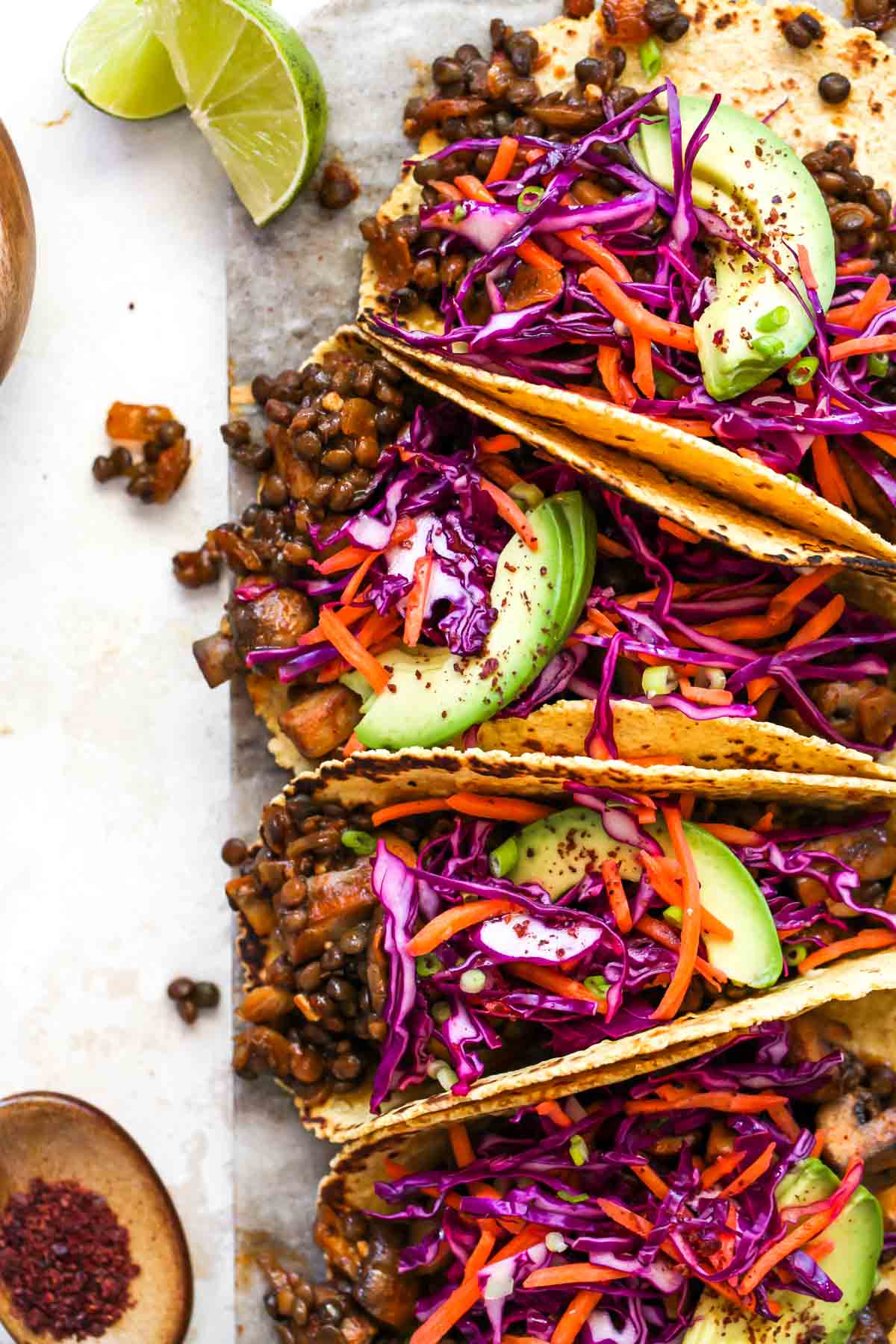 Mushroom and lentil tacos topped with cabbage slaw and avocado