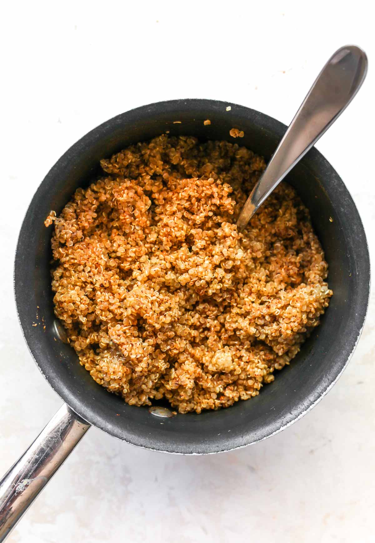 Cooked quinoa in a small black saucepan