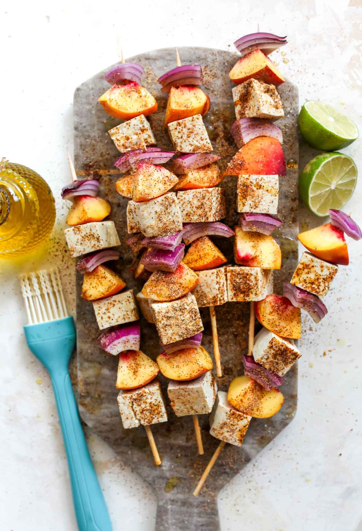 Tofu kebabs being seasoned with chili powder