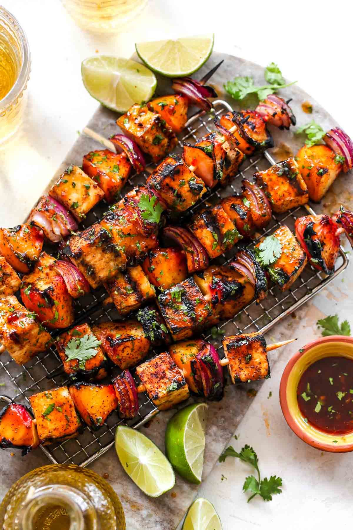Tofu, peach, and red onion skewers on a cutting board