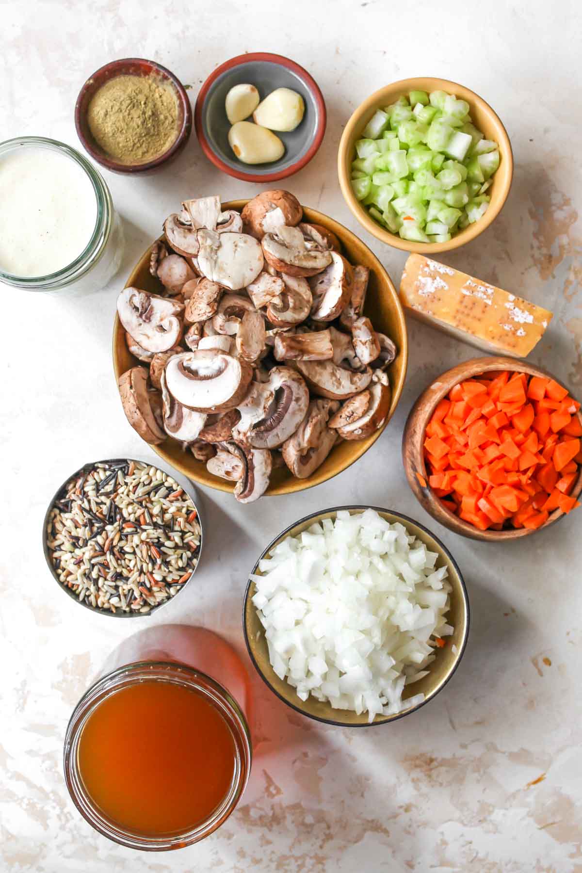 Wild rice and mushroom soup ingredients in separate bowls on a white board