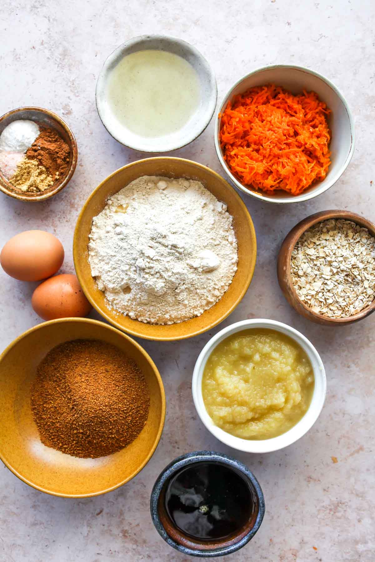 Carrot apple bread ingredients in separate bowls on a white board