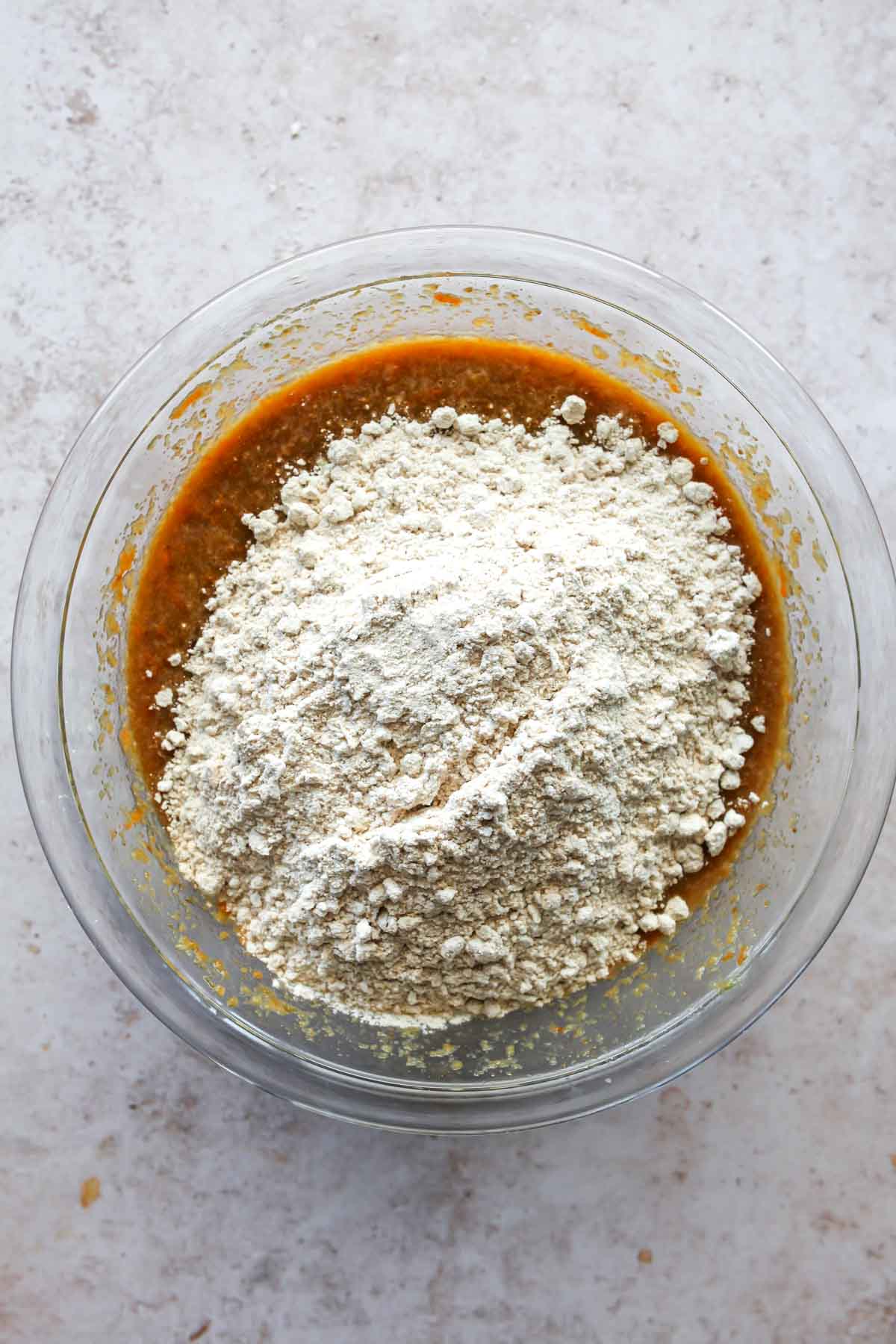 Dry ingredients being added to a bowl of wet ingredients