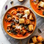 Roasted eggplant and tomato soup in a gold bowl topped with croutons