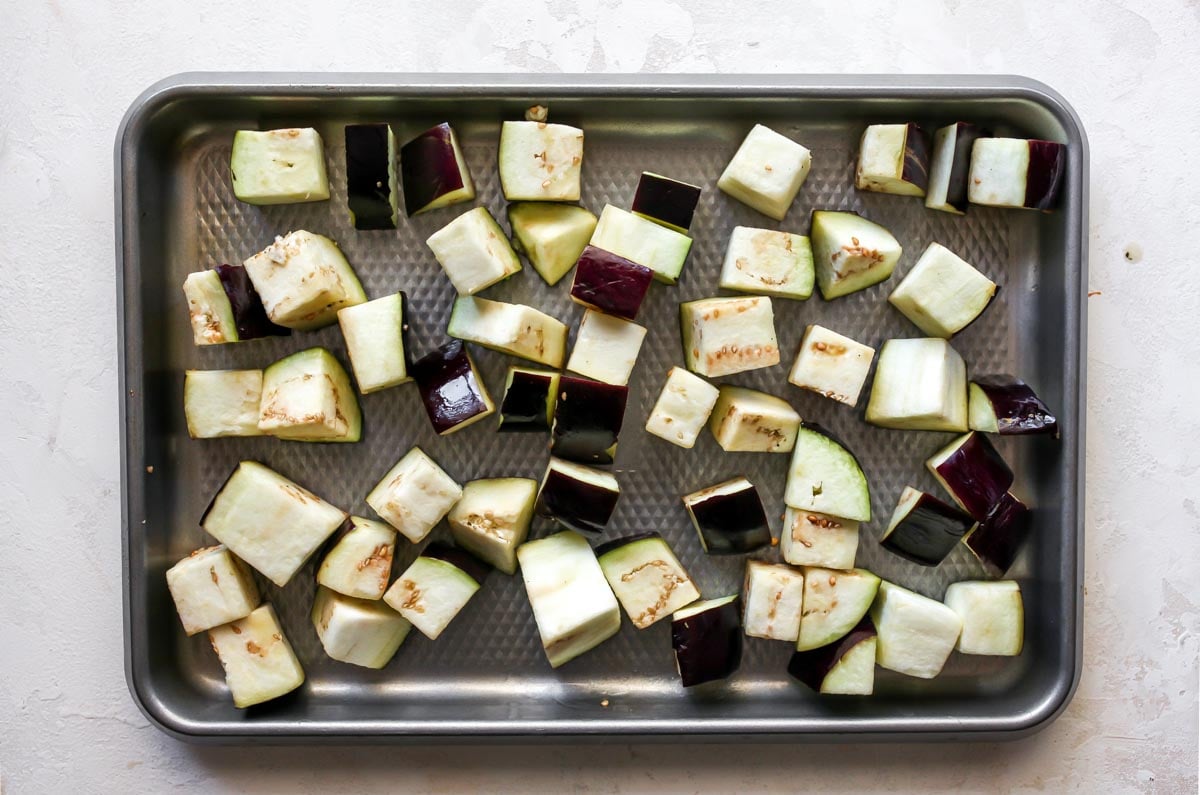 Cubes of eggplant on a silver baking sheet