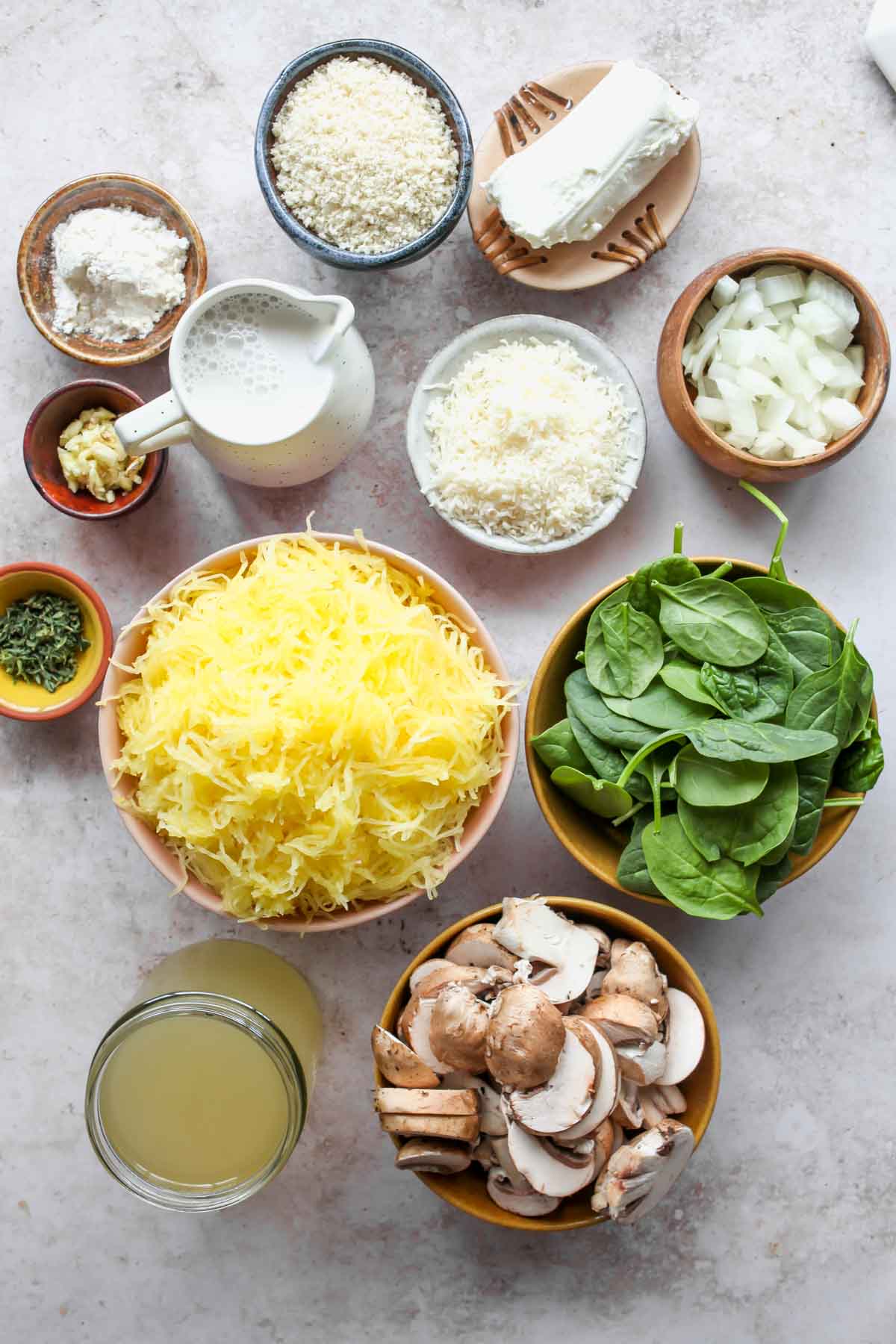 Spaghetti squash casserole ingredients in separate bowls on a white board
