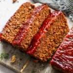 Three slices of vegan meatloaf on a cutting board