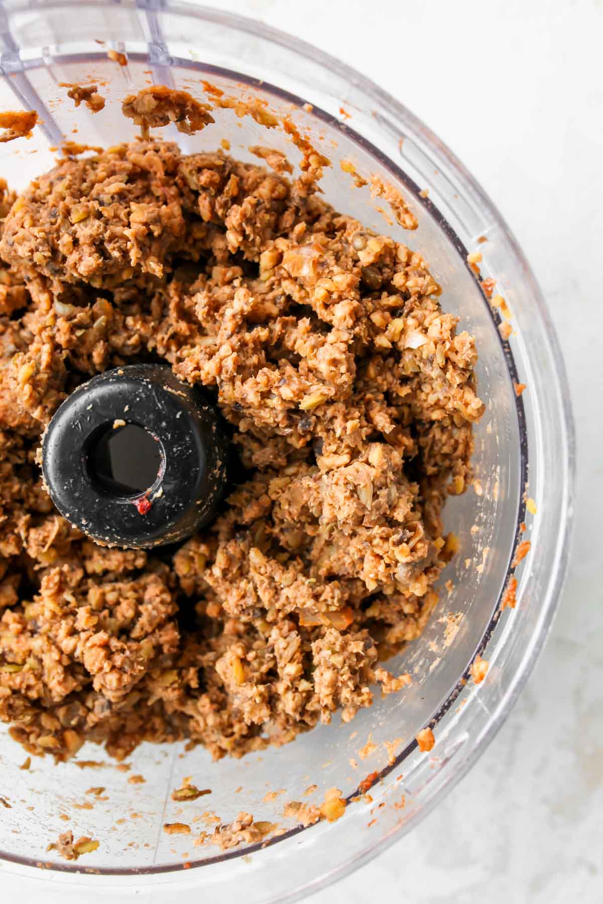 Mushroom lentil mixture in the bowl of a food processor