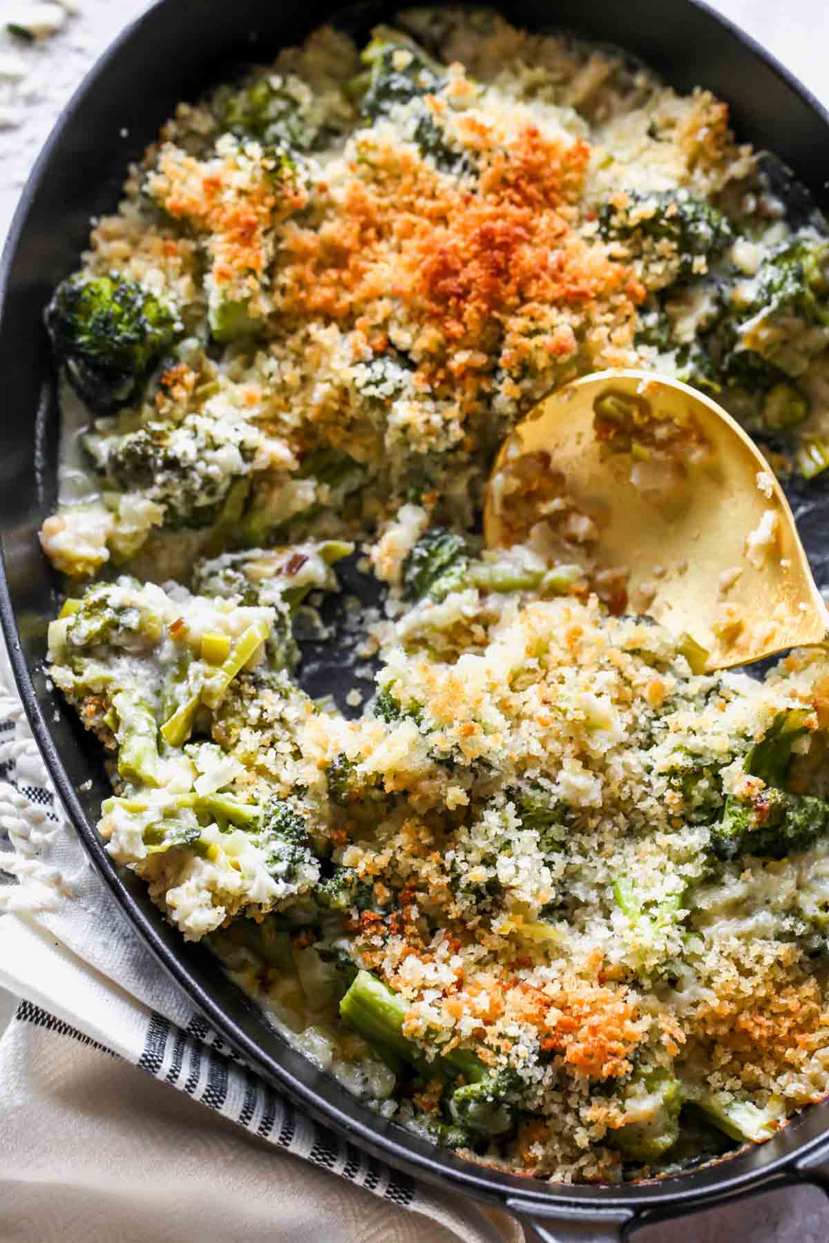 Spoon pulling out a serving of broccoli casserole