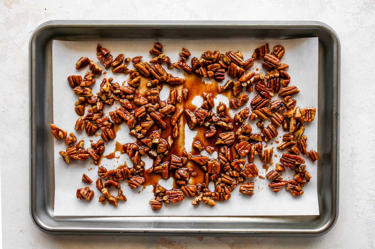 Pecan praline on a parchment-lined baking sheet cooling