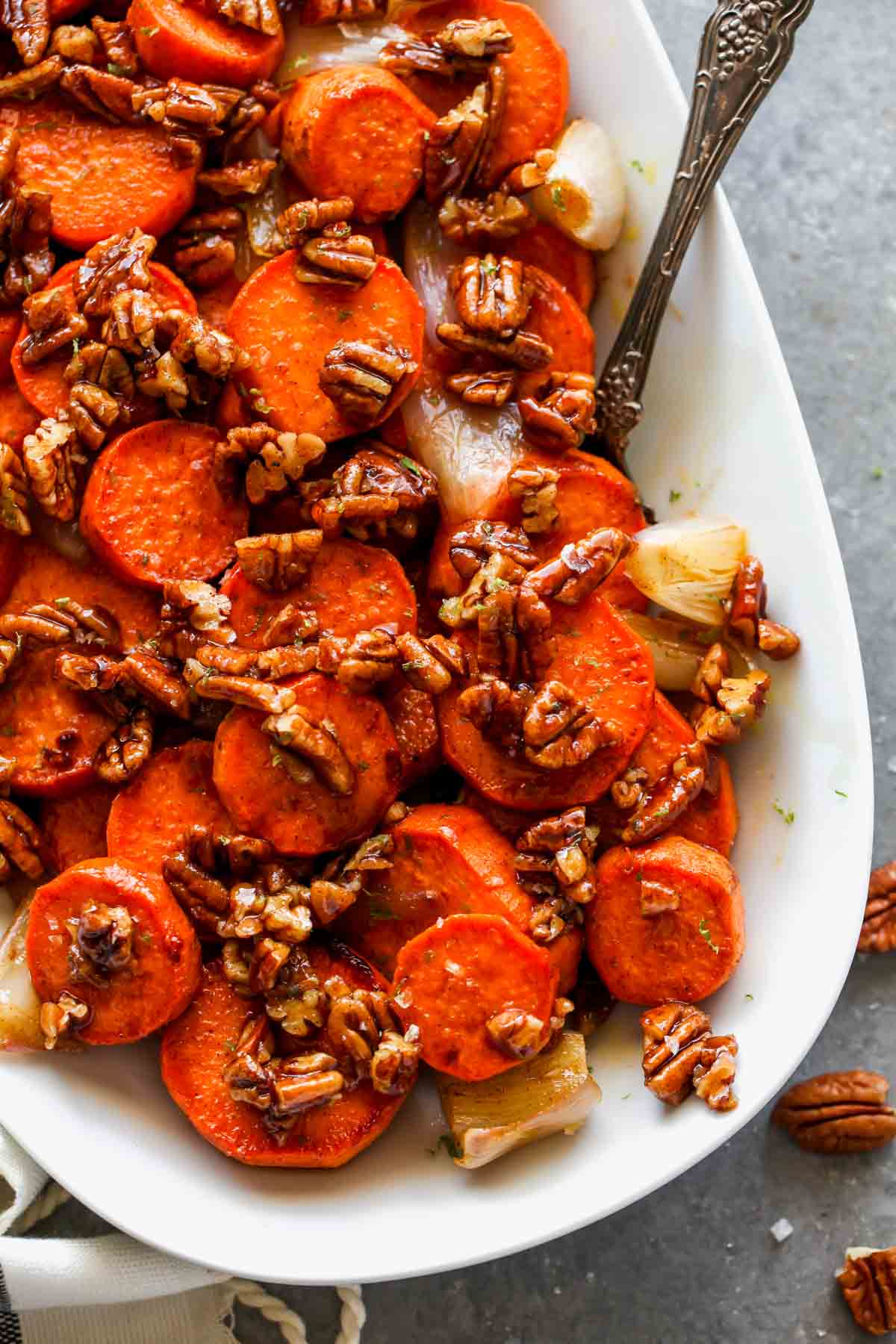 Pecan praline topped potatoes on a white platter